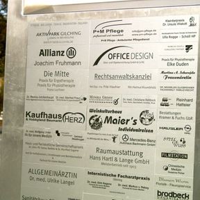 Wand mit Schildern als Gebäudebeschriftung von zahlreichen Unternehmen in Oberösterreich