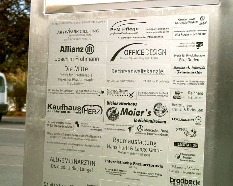 Wand mit Schildern als Gebäudebeschriftung von zahlreichen Unternehmen in Oberösterreich